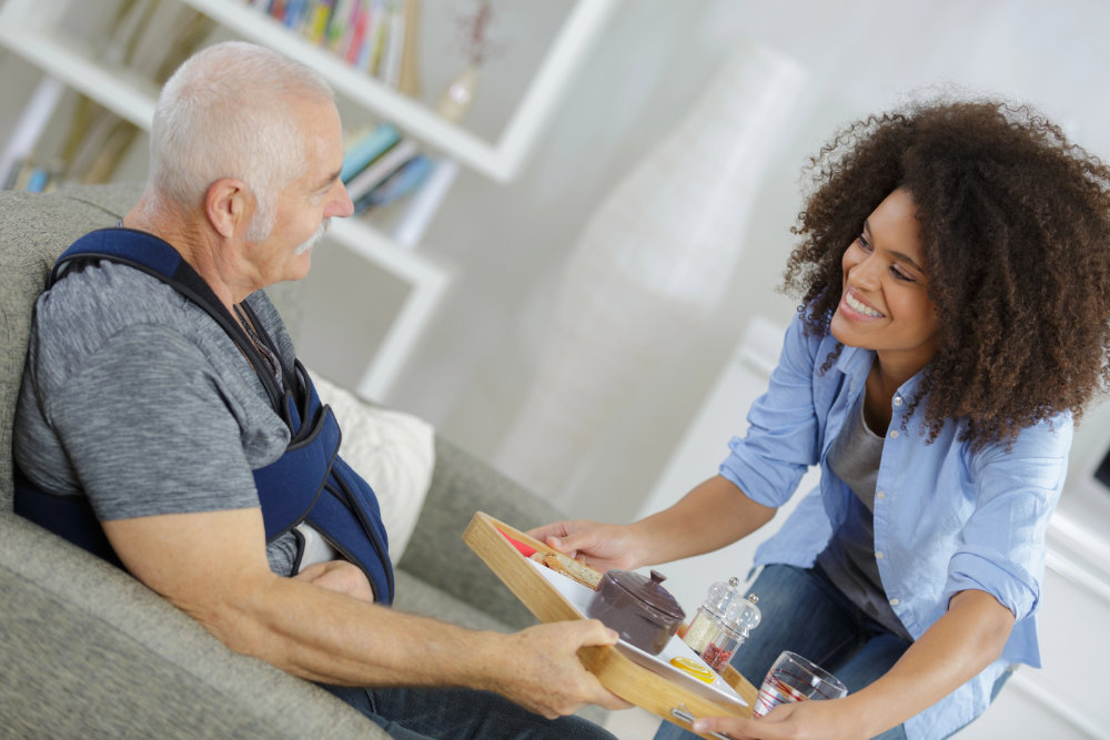 Senior being served a meal by a respite care worker.