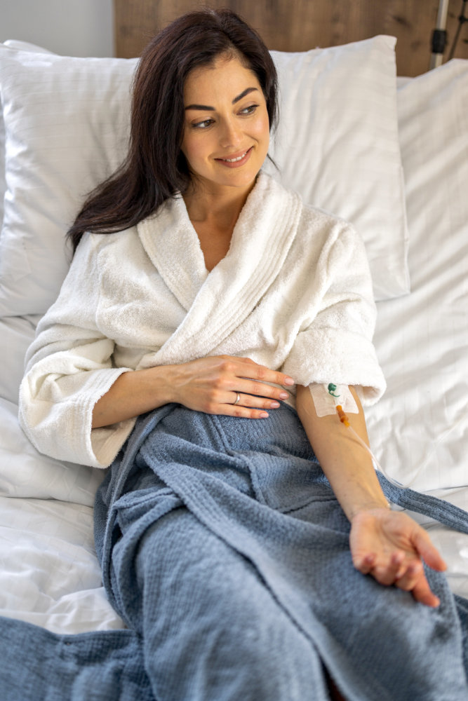 Woman in bed getting a home infusion