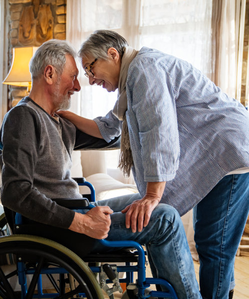 Mature man with disability in wheelchair having fun with wife