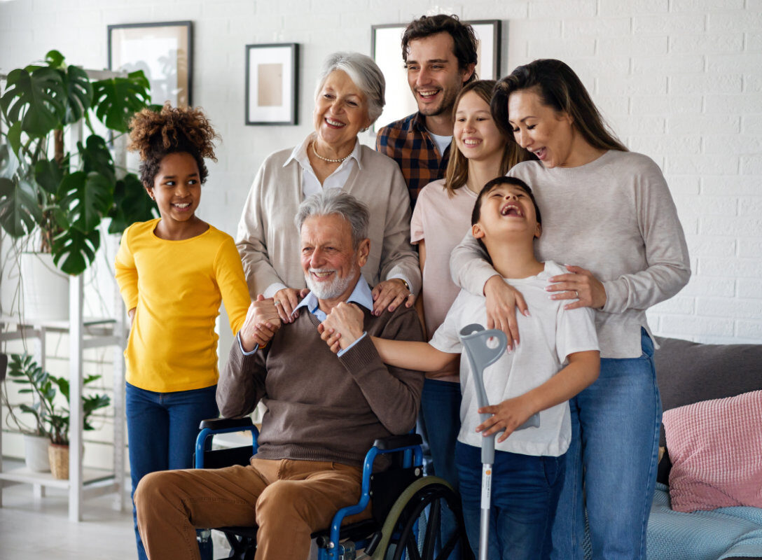 Multi generation, multiethnic family at home together, grandfather with disability.