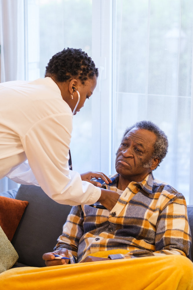 Sick senior man attended by doctor with home care - health care concept