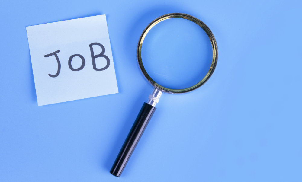 Conceptual picture with a magnifying glass and a text 'job' on a blue background