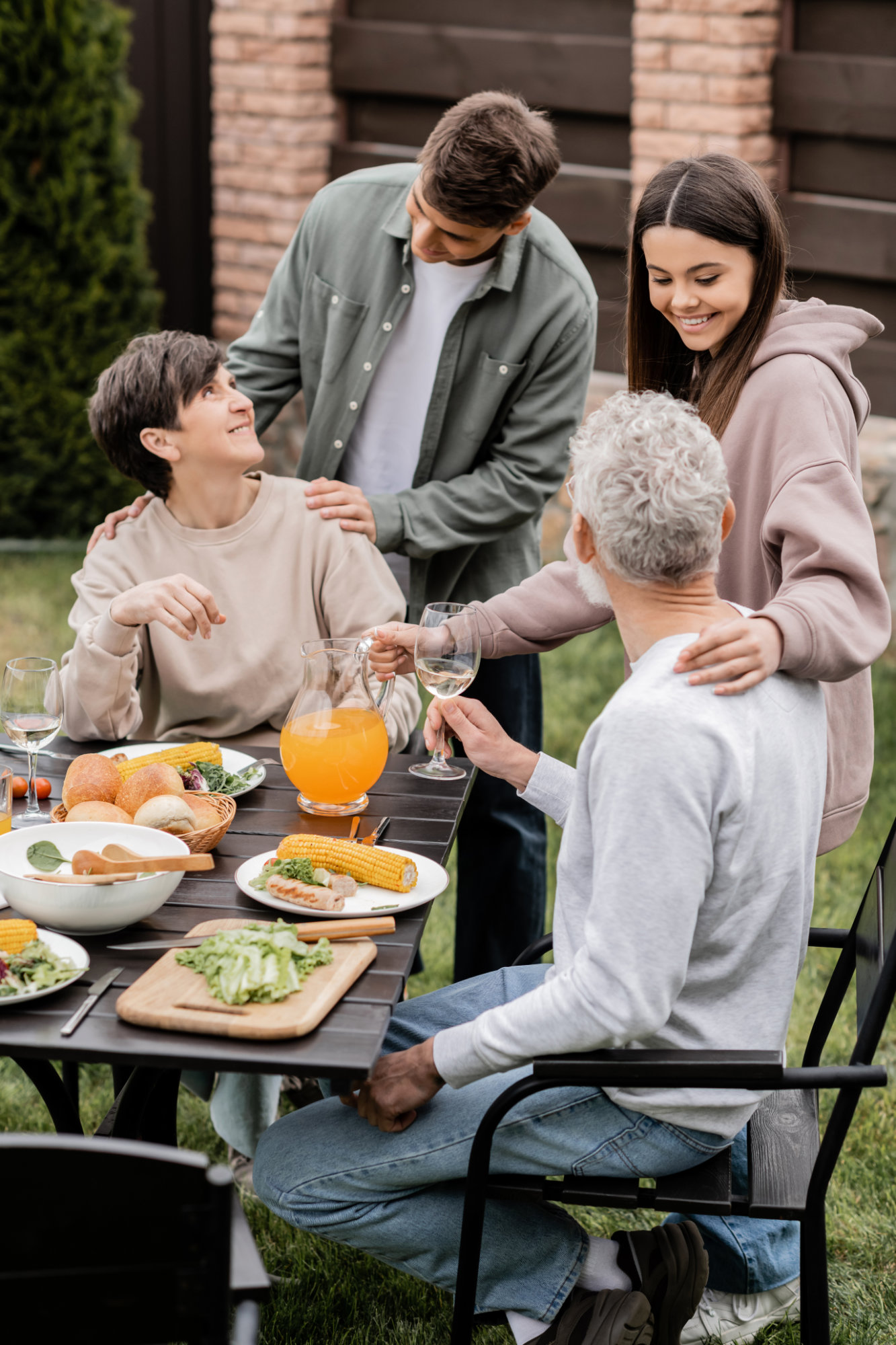 Positive siblings hugging and talking to middle aged parents